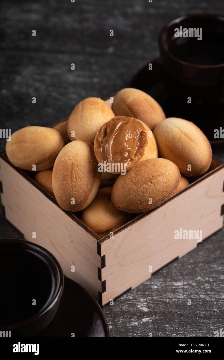 photo homemade pastry with condensed milk and two cups of drink Stock Photo