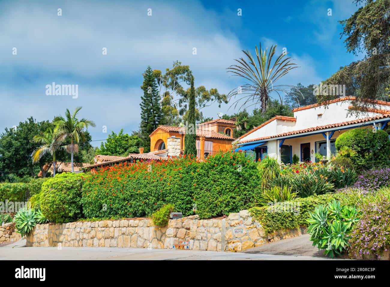 Houses and lush front yards in a hillside residential neighborhood in