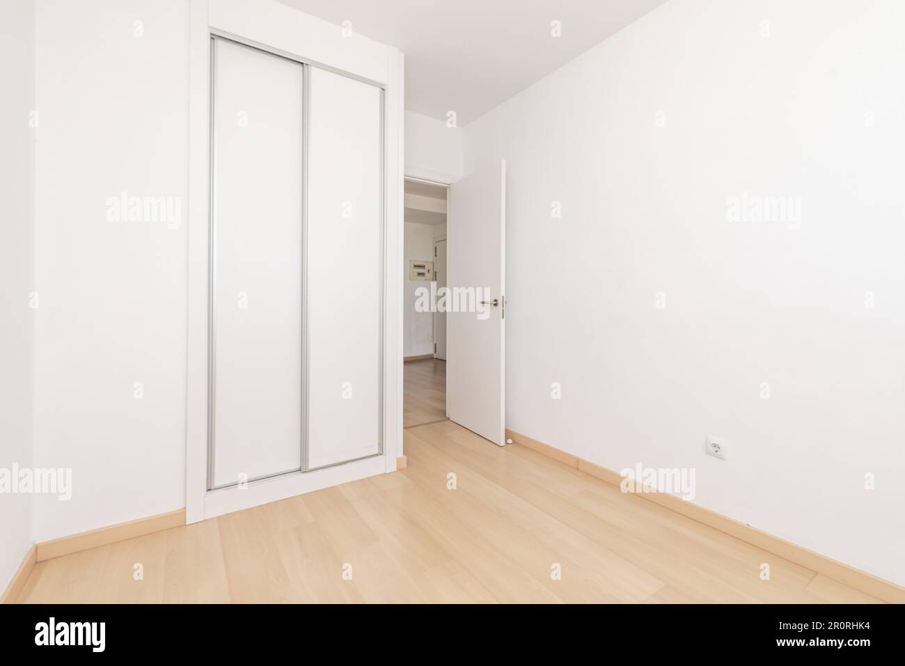 An empty room in an apartment with a built-in wardrobe with white sliding doors Stock Photo