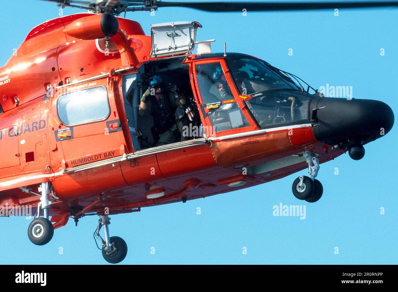 Aviation Electronics Technician 3rd Class Reid Schneider waves as an Airbus MH-65 helicopter departs the  U.S. Coast Guard Cutter Active (WMEC 618), in the Eastern Pacific Ocean, March 17, 2023. Active is on patrol off the coast of Mexico as part of a joint interagency task force designed to detect and deter transnational criminal activity operating in the region. (U.S. Coast Guard photo by Petty Officer 2nd Class Justin Upshaw). Stock Photo