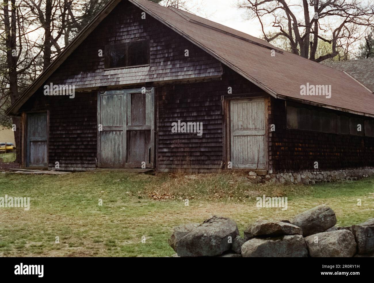 Lexington, Massachusetts USA - April 2023 - A weather worn wood barn stands alongside Battle Road in the Minuteman National Historical Park during the Stock Photo