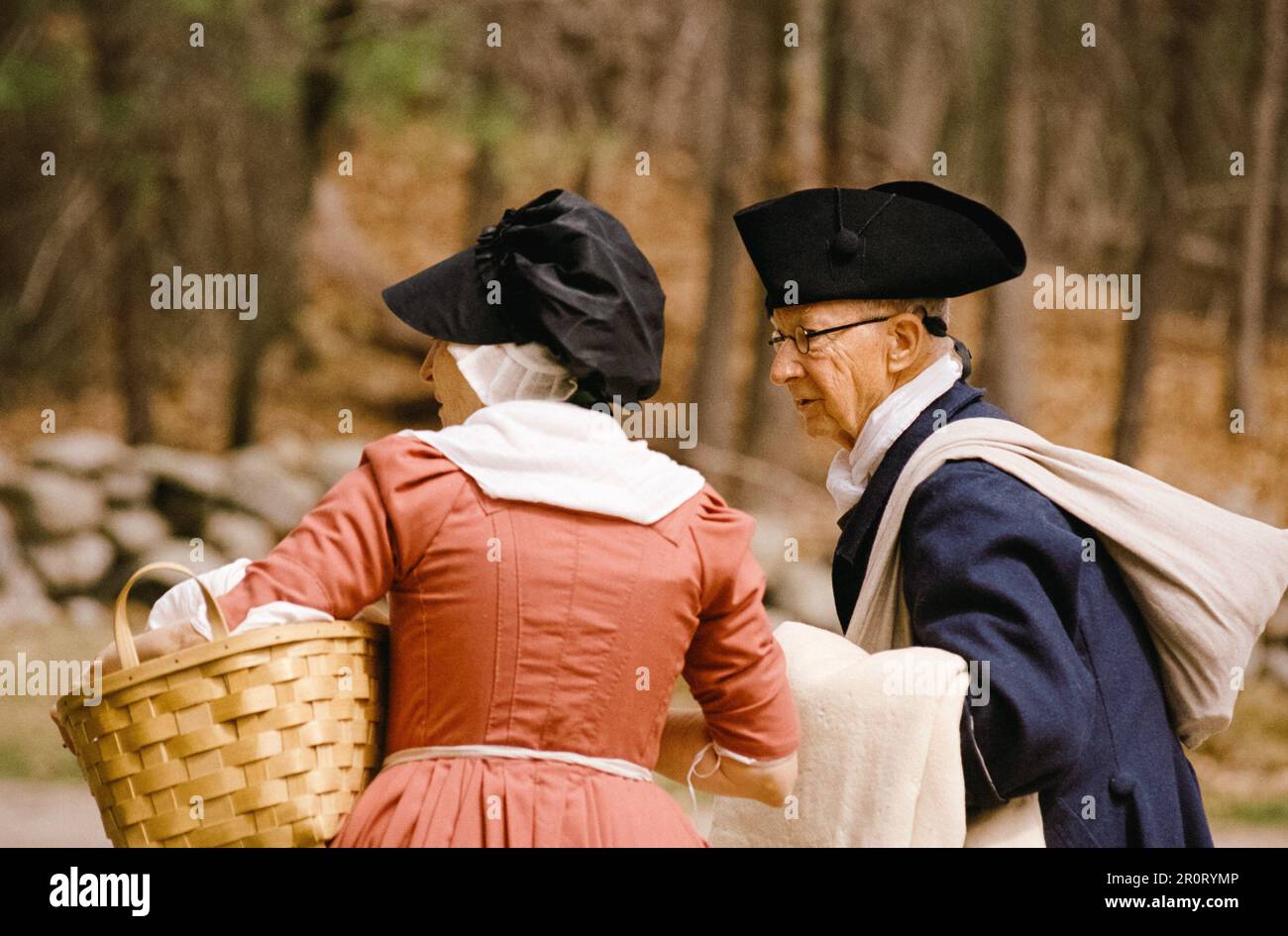 Lexington, Massachusetts USA - April 2023 - A woman and man carrying their belongings down Battle Road  in the Minuteman National Historical Park duri Stock Photo