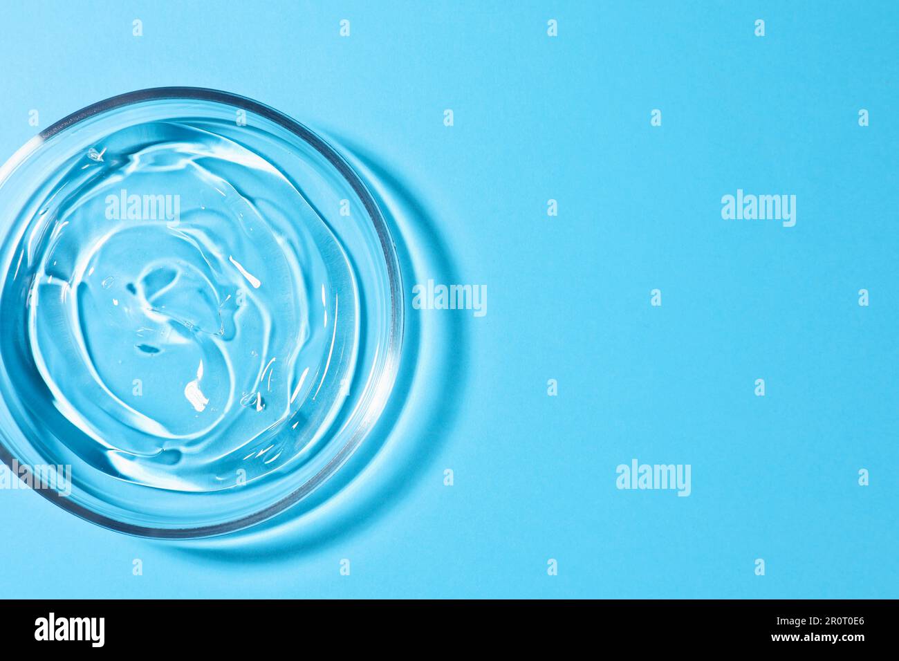 Petri dish with liquid on light blue background, top view. Space for ...