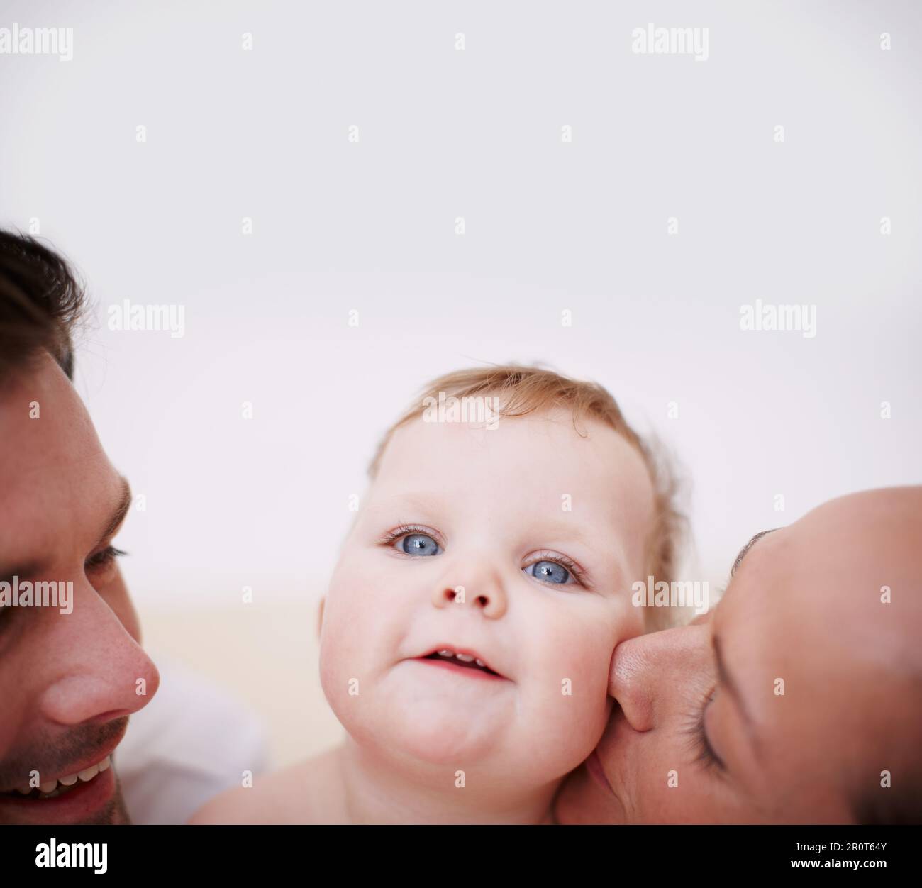 Showering her with love. Two loving young parents showing affection to