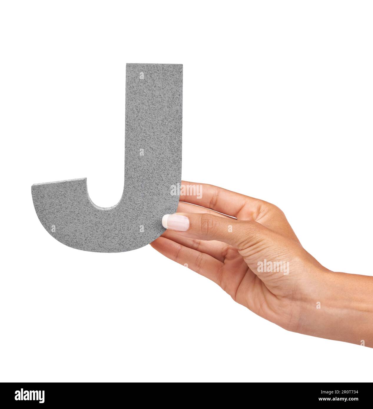 The letter J. A young woman holding a capital letter J isolated on a white background. Stock Photo