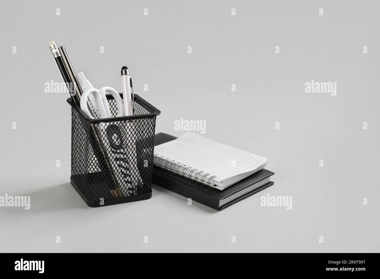Stationery holder and notebooks on grey background Stock Photo