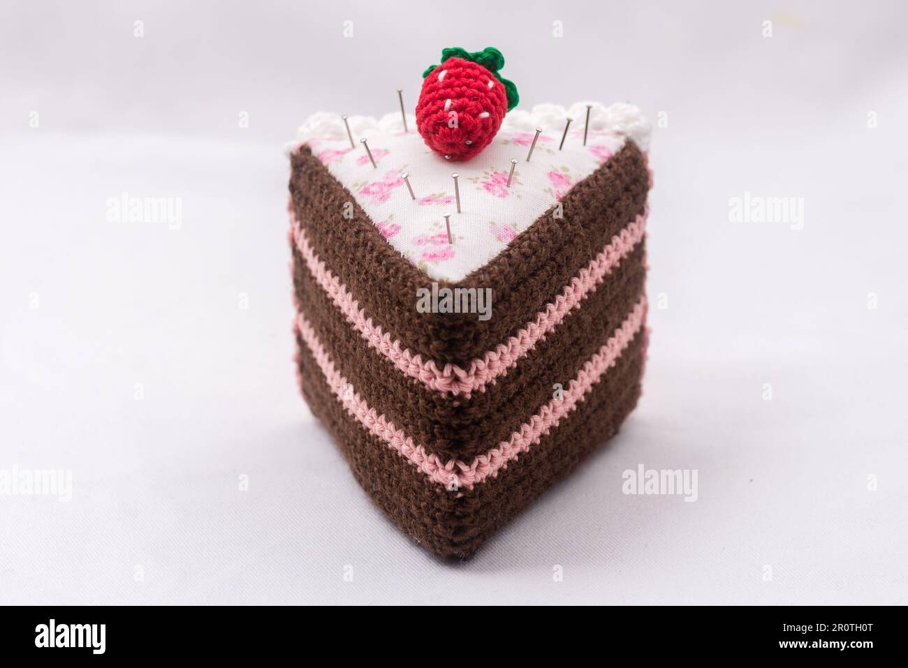Chocolate and raspberry cake pincushion with a strawberry on top Stock