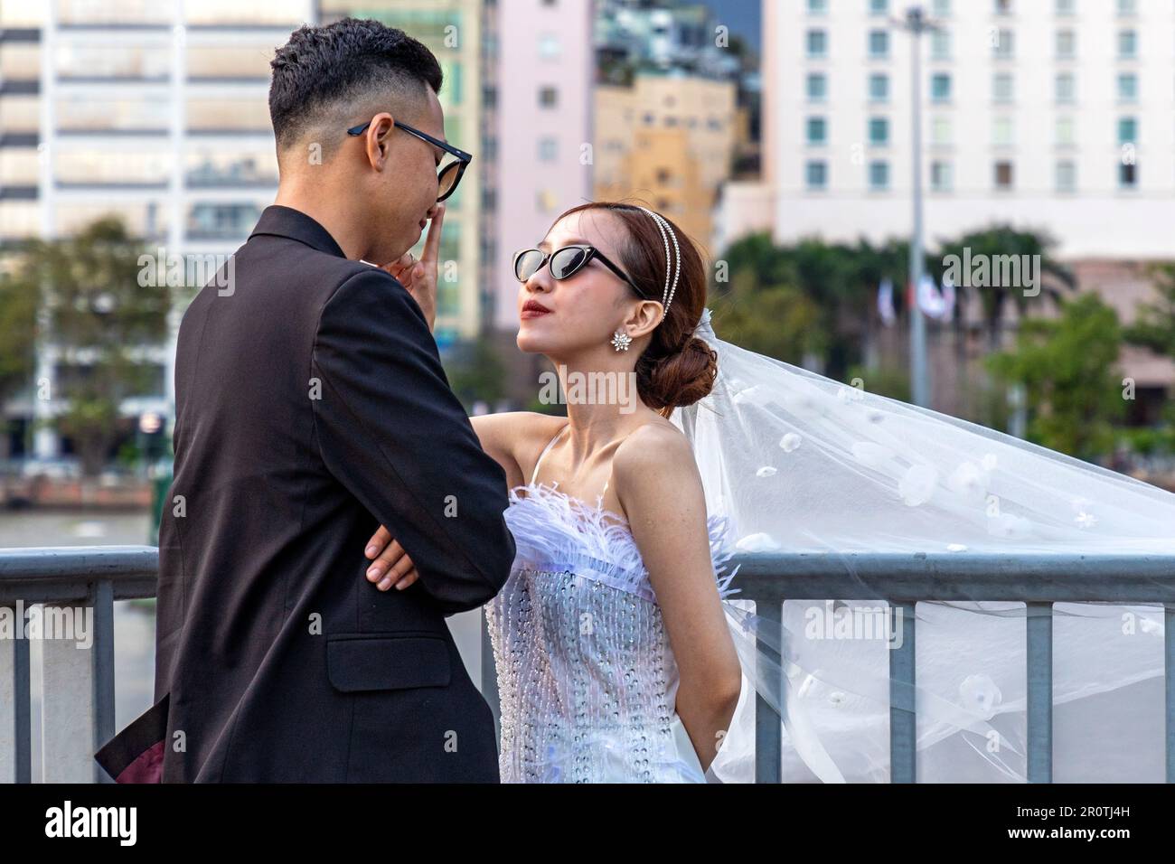 Vietnamese wedding couple posing for photographs in front of Ho Chi