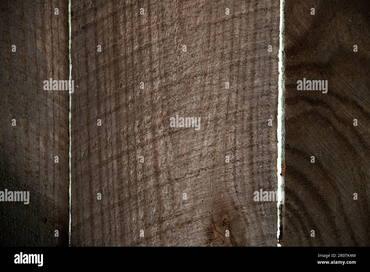 close up of rough sawn fence boards with gaps between the boards, wood