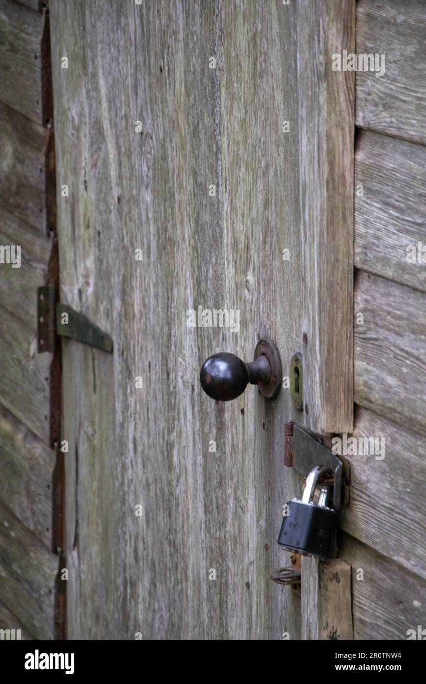 Rustic wooden cabin door lock and handle with rusted hinges Stock Photo