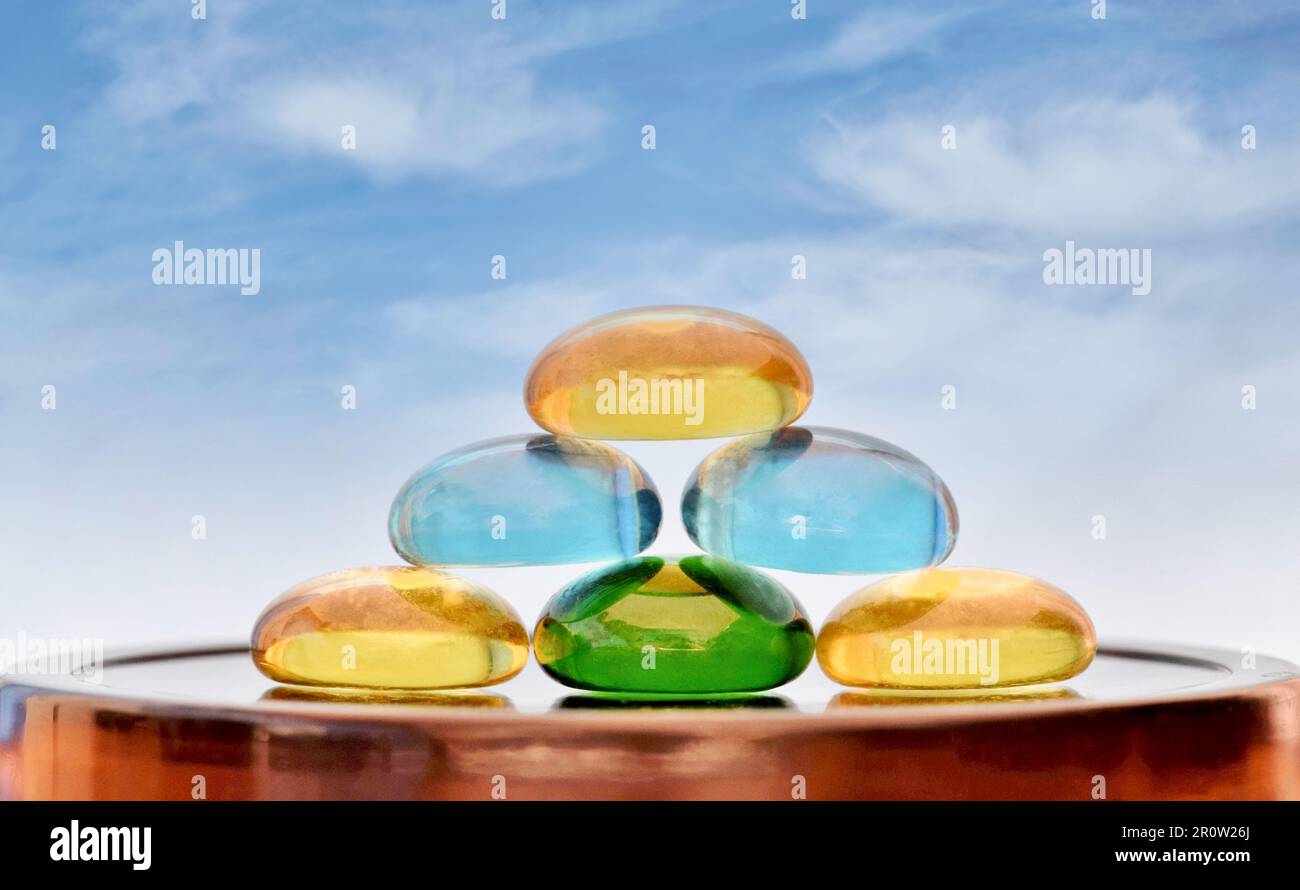 Stack of colored glass stones with a blue sky background and copy space. Zen concept of life balance, tranquility, feng shui and related topics. Stock Photo