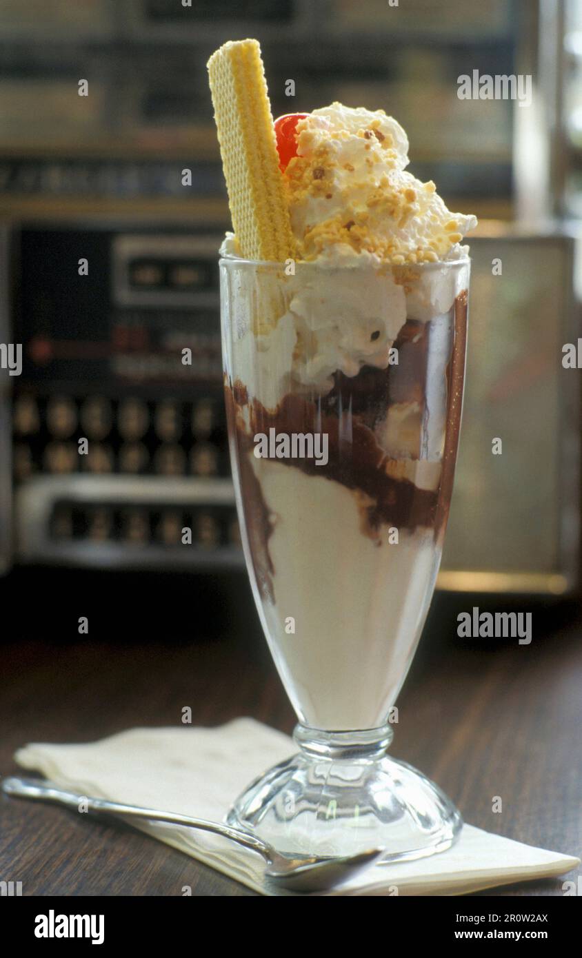 A large ice cream sundae with vanilla, chocolate ice cream and whipped