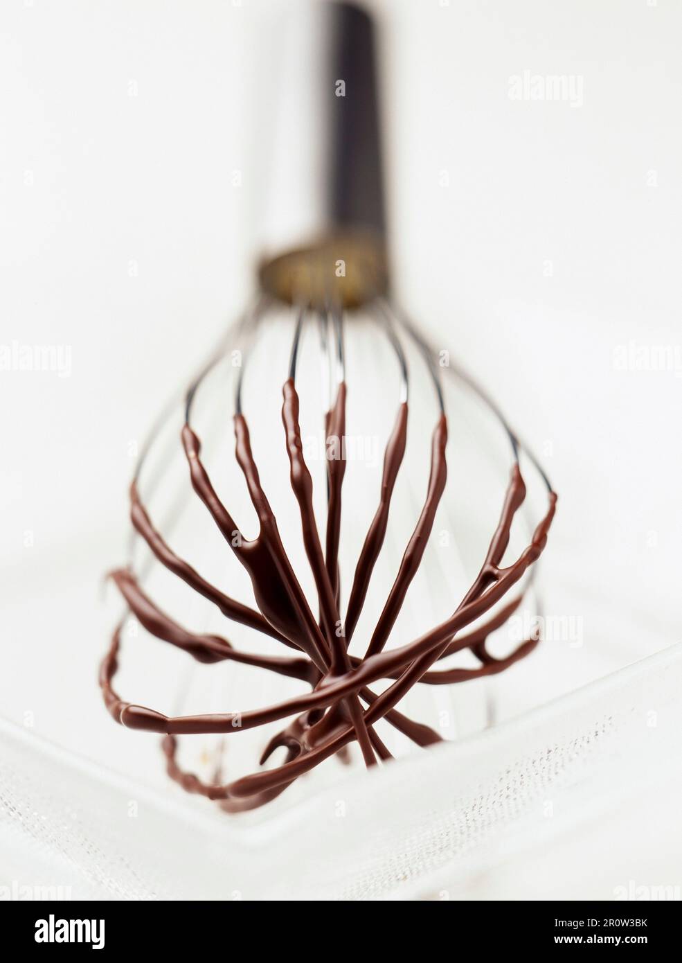 Whisk with melted chocolate Stock Photo