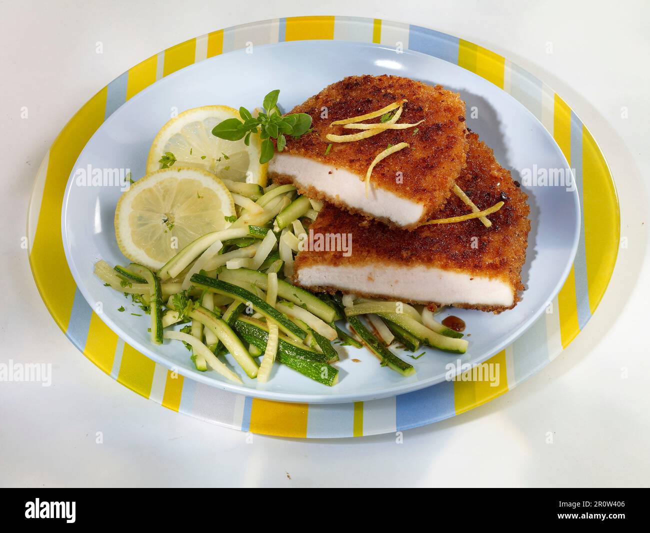 Escalopes breaded with gingerbread crumbs and courgette julienne with lemon Stock Photo