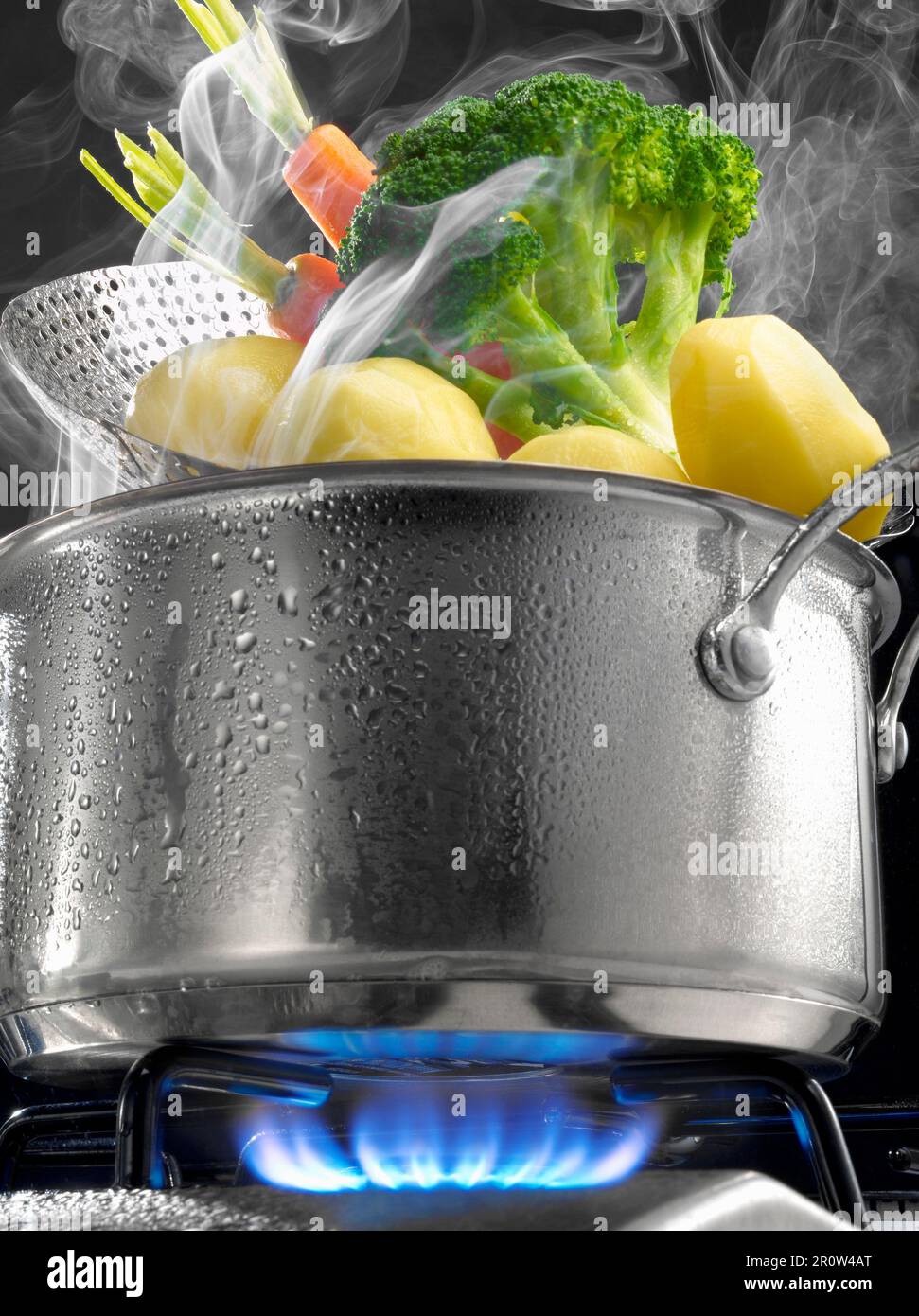 Steam cooking vegetables in a saucepan on a gas cooker Stock Photo Alamy