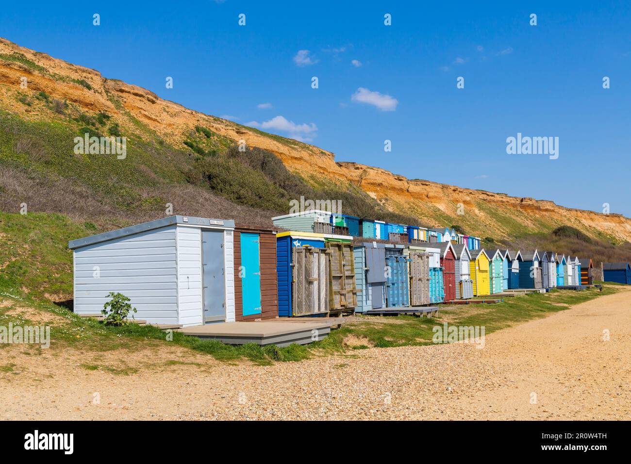 Beach huts at BartononSea on a sunny day at Barton on Sea, Hampshire, UK in April Stock Photo