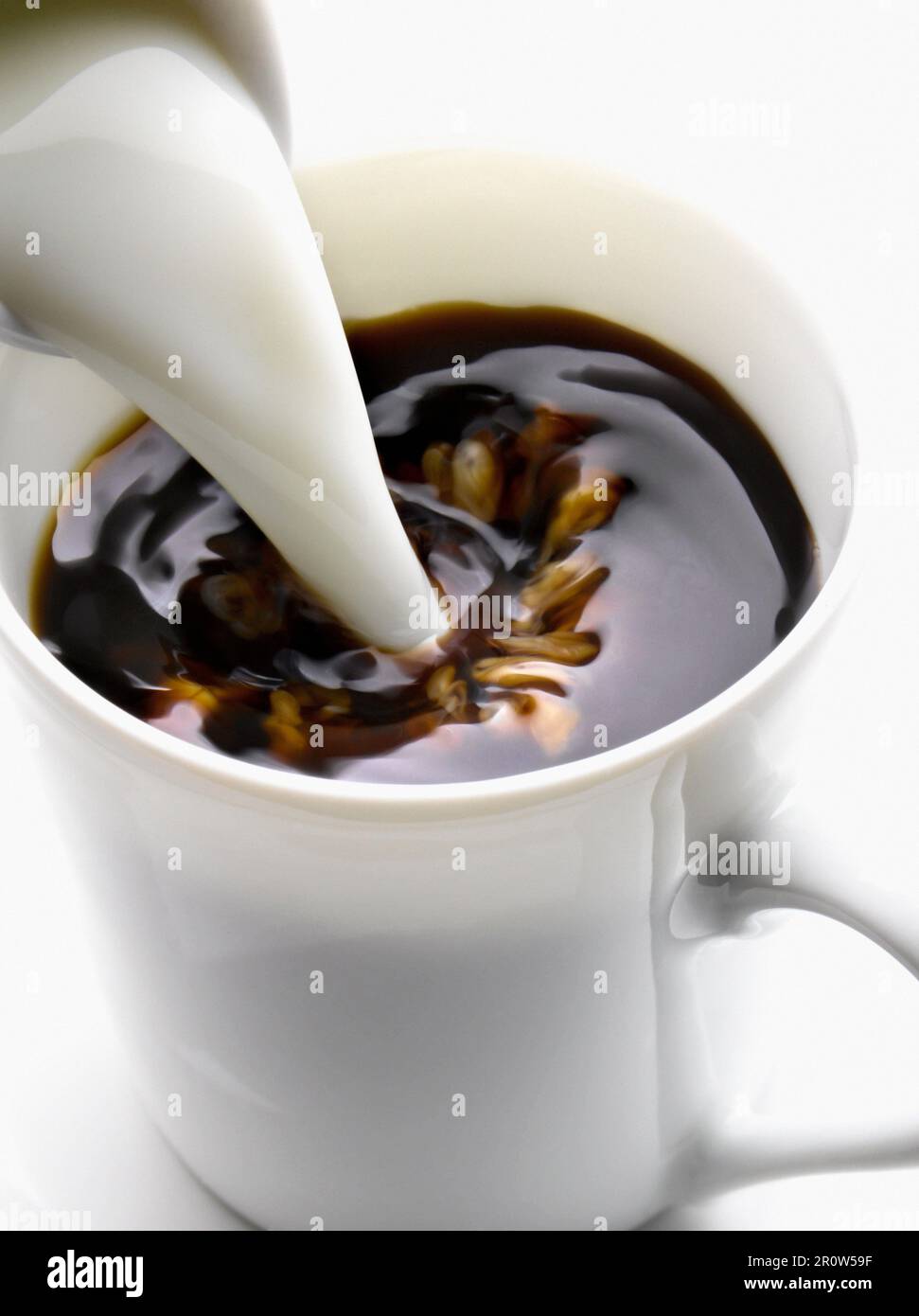 Adding milk to a cup of coffee Stock Photo Alamy