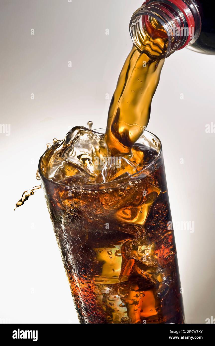 Pouring a glass of Coca-cola with ice cubes Stock Photo - Alamy