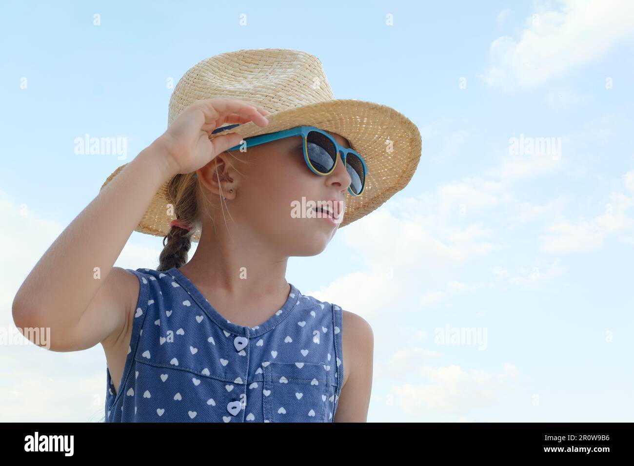 Little girl wearing sunglasses and hat at beach on sunny day Stock Photo Alamy