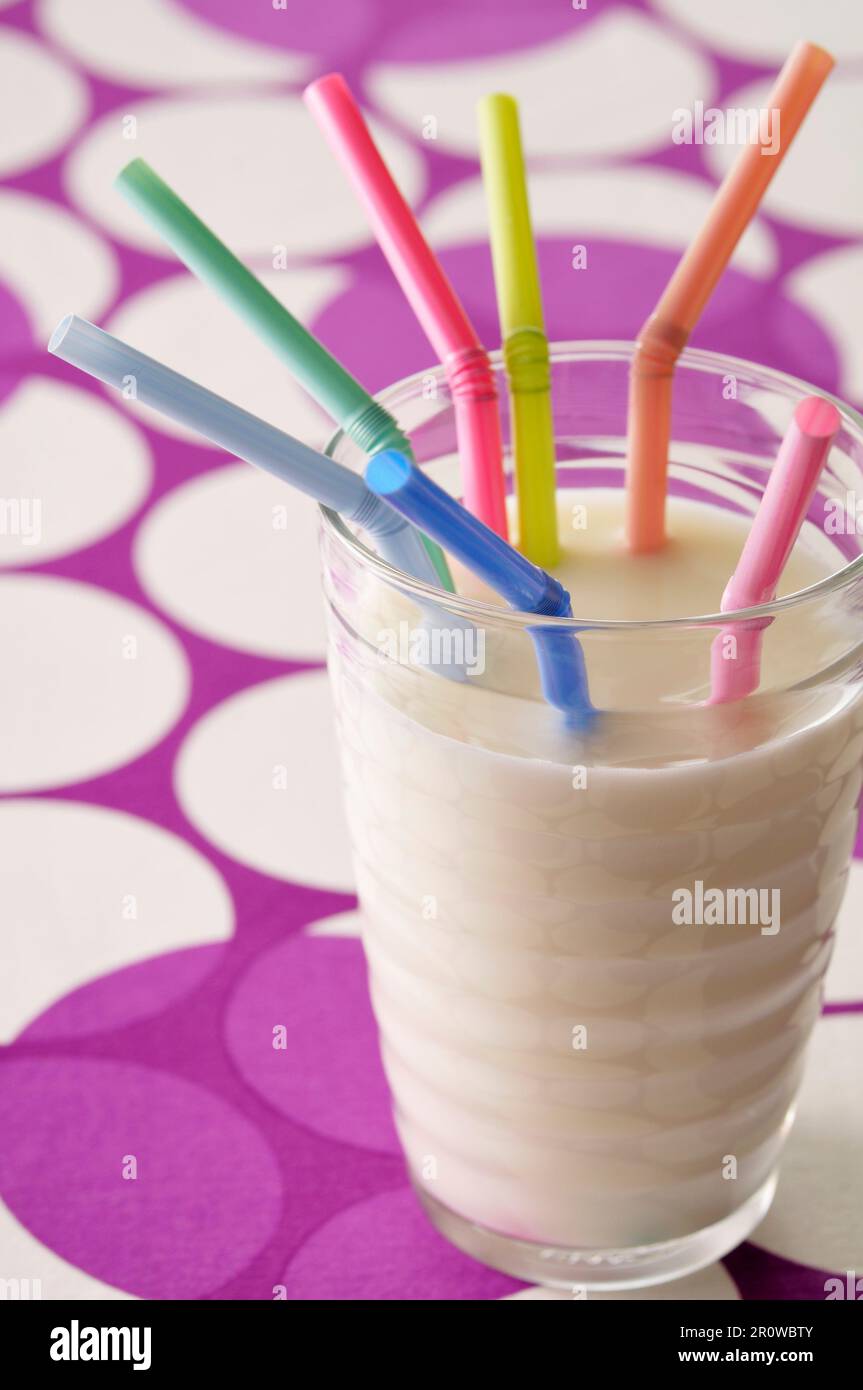 Glass of milk with colored straws Stock Photo