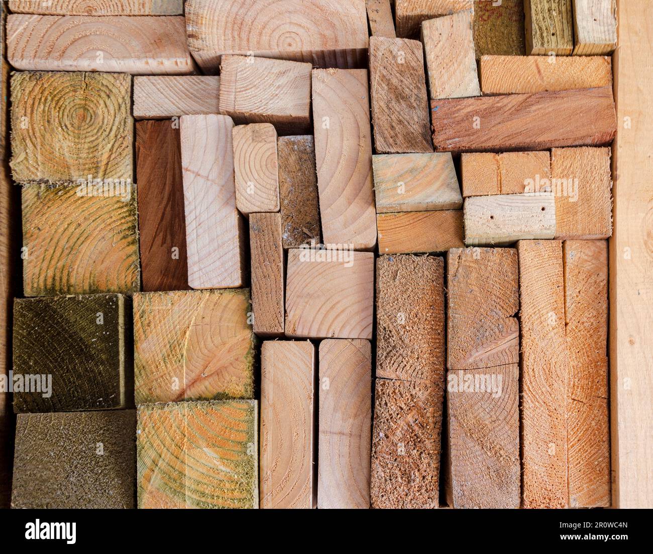 Various types of wooden planks and blocks stored in a crafters workshop with end grain showing Stock Photo
