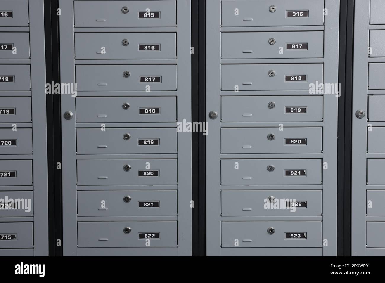 Closed metal mailboxes with keyholes and sequence numbers indoors Stock