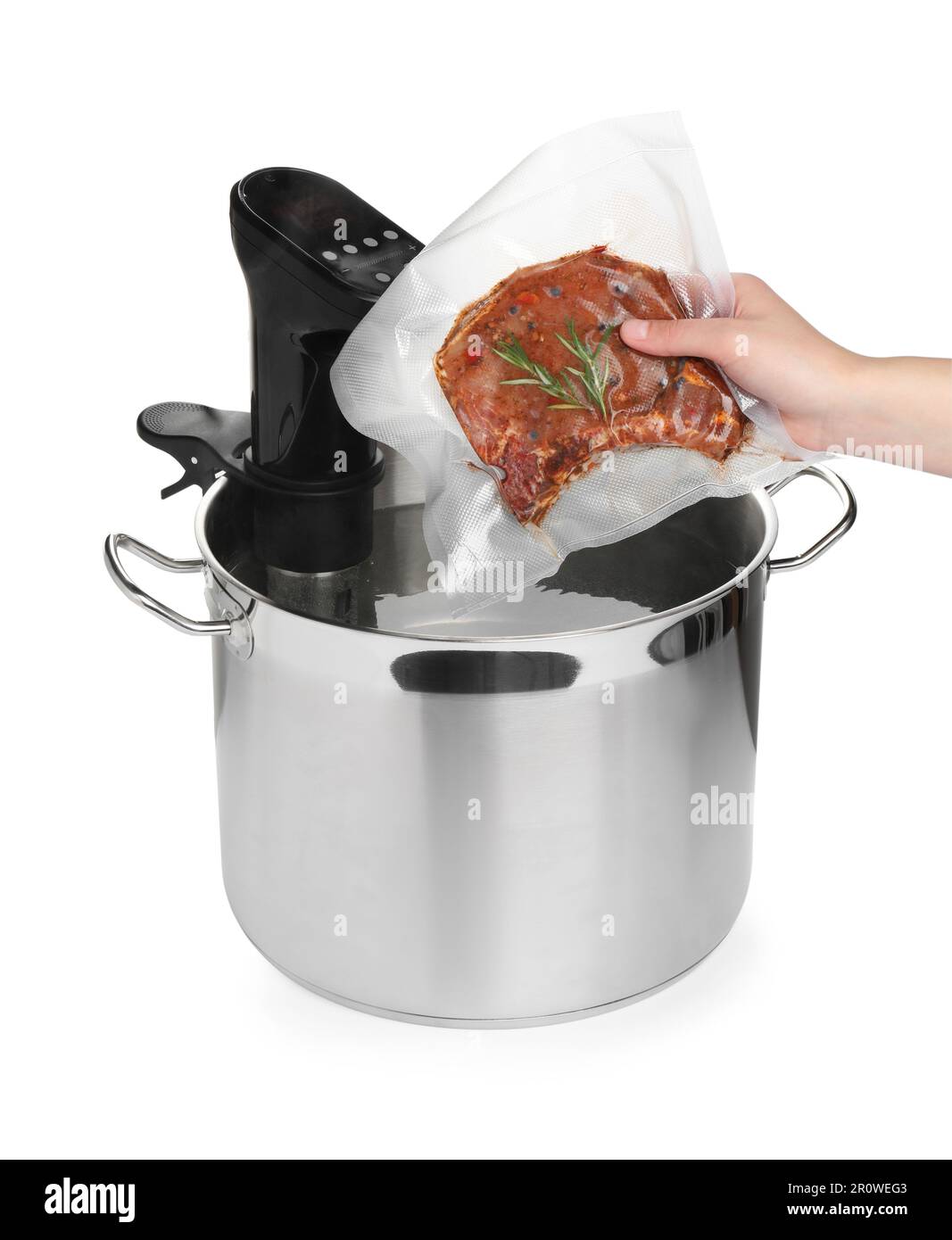 Woman putting vacuum packed meat in pot with sous vide cooker on white