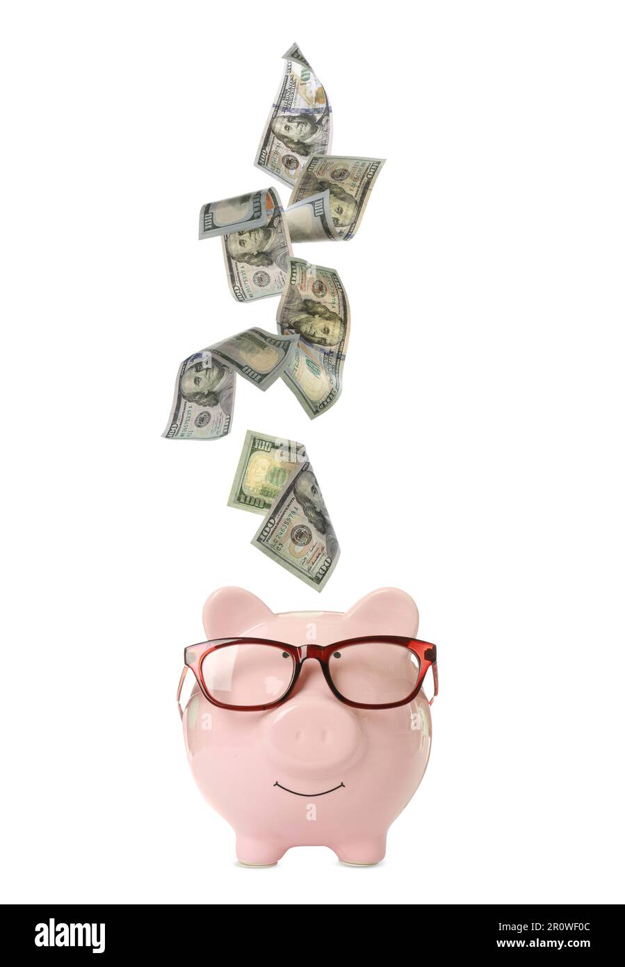 Dollar banknotes falling into pink piggy bank with glasses on white ...
