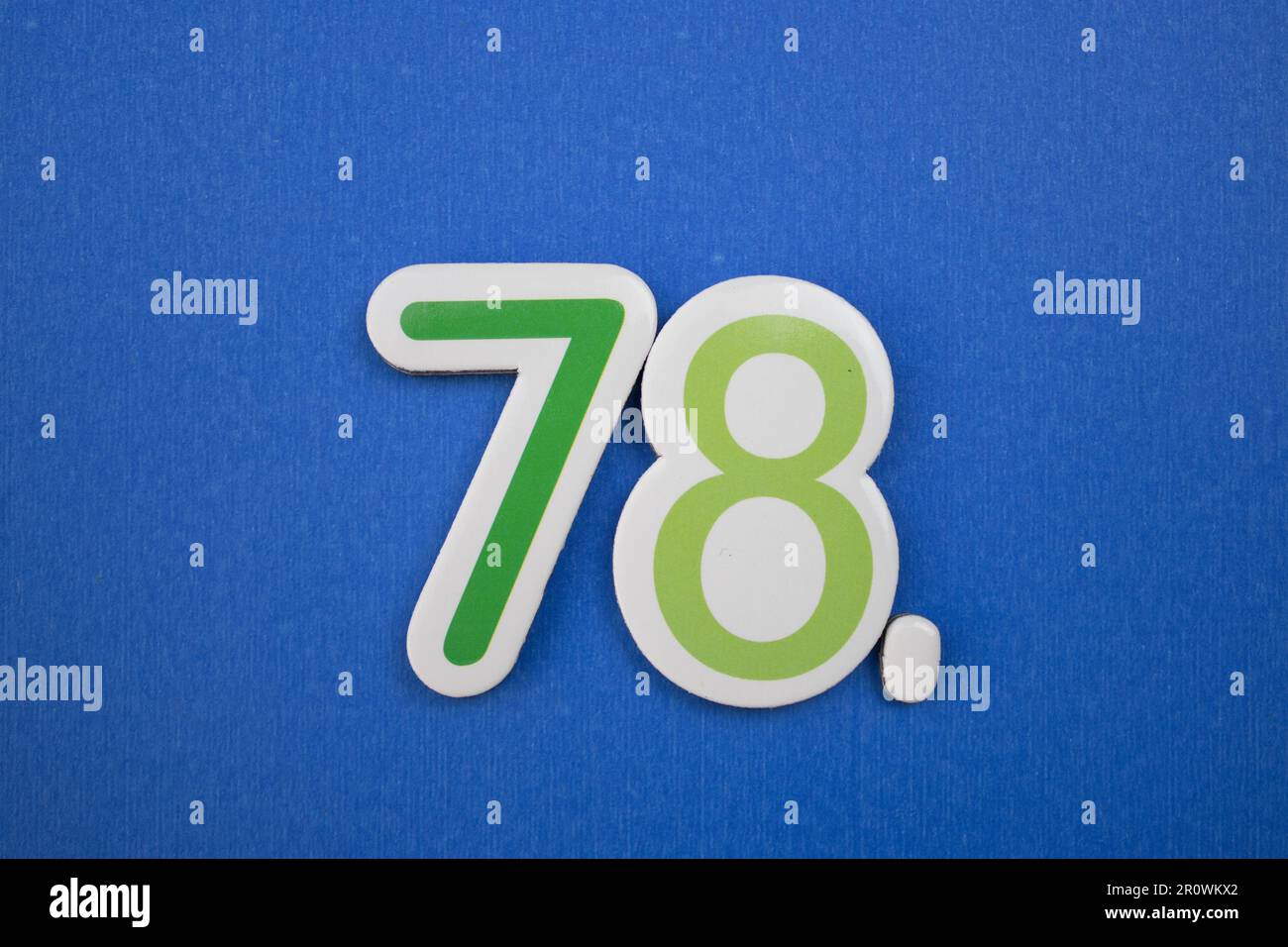 The number 78 in green color, photographed from above, placed on a blue ...