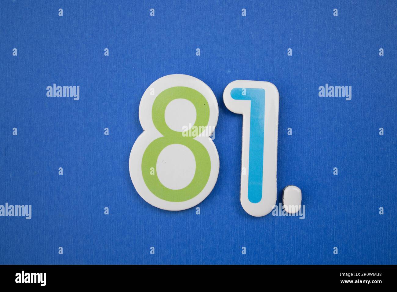 The number 81, placed on a blue background, photographed from above, colored green and light blue. Stock Photo