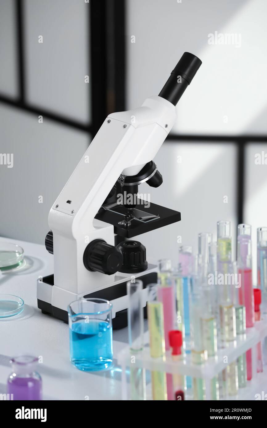 Modern microscope with glass slide on white table in laboratory Stock ...