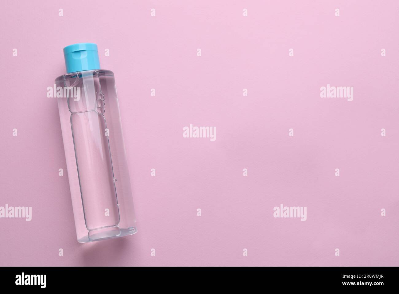 Micellar water on pink background, top view. Space for text Stock Photo