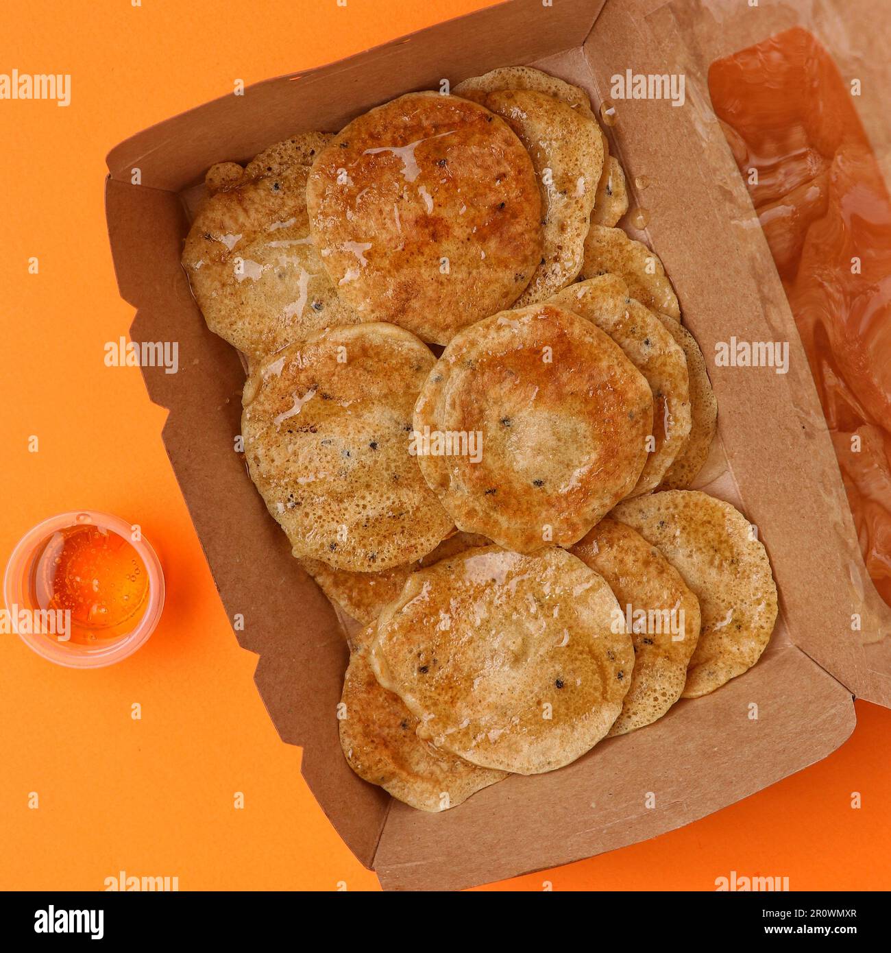 cookies with poppy seeds in a paper box on an orange background Stock Photo