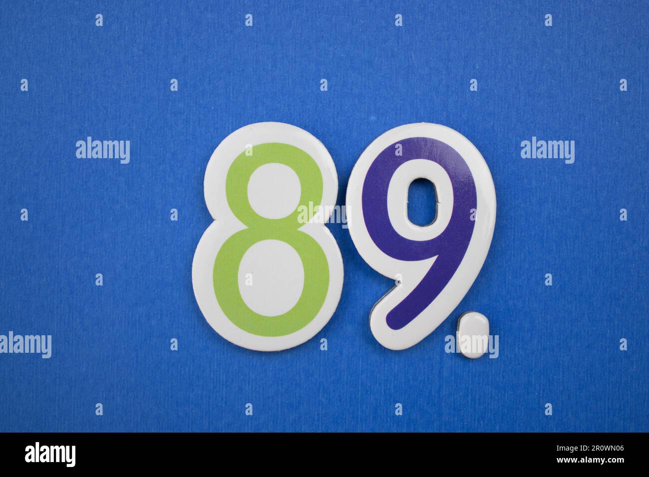 The number 89, placed on a blue background, photographed from above, in ...