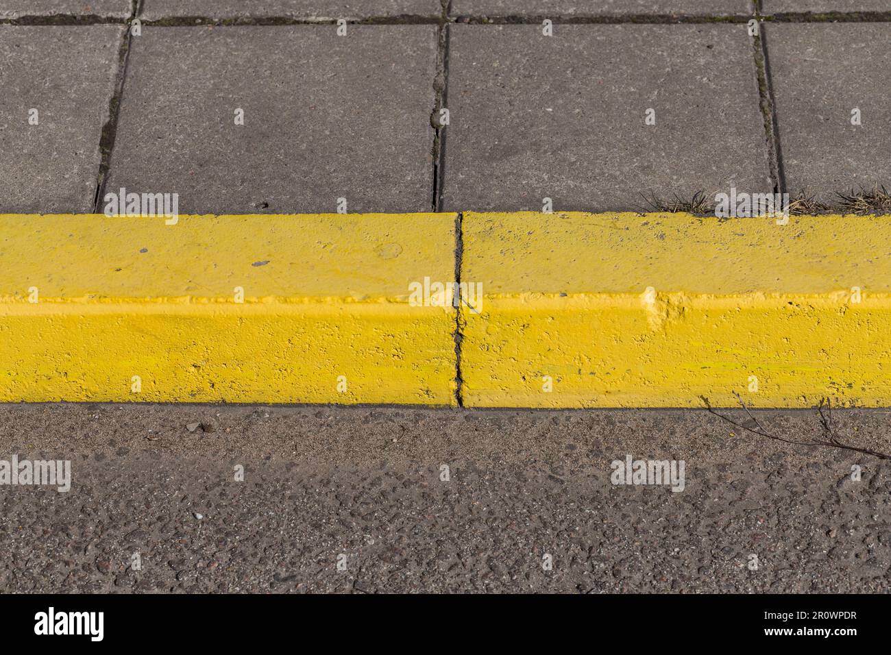 Yellow curb stone border and asphalt road Stock Photo Alamy