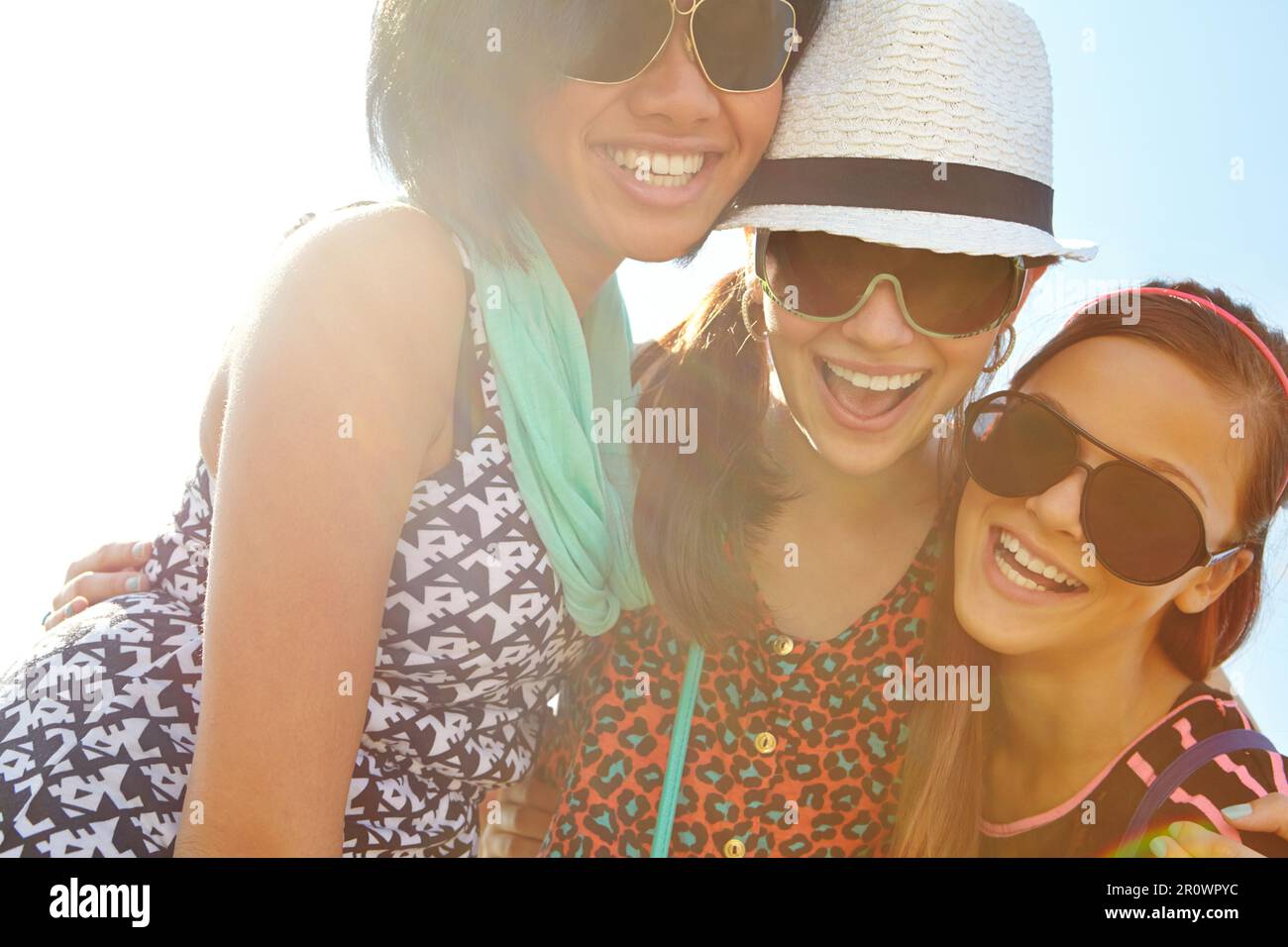 Three of a kind. Closeup shot of a group of teenage girls smiling with their arms around each others shoulders. Stock Photo