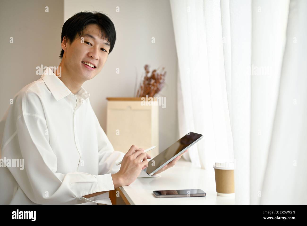 Smart and handsome young Asian male freelancer or college student in ...