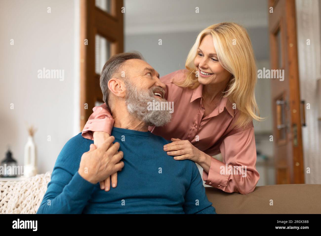 Happy European Spouses Embracing Expressing Happiness Posing At Home Stock Photo