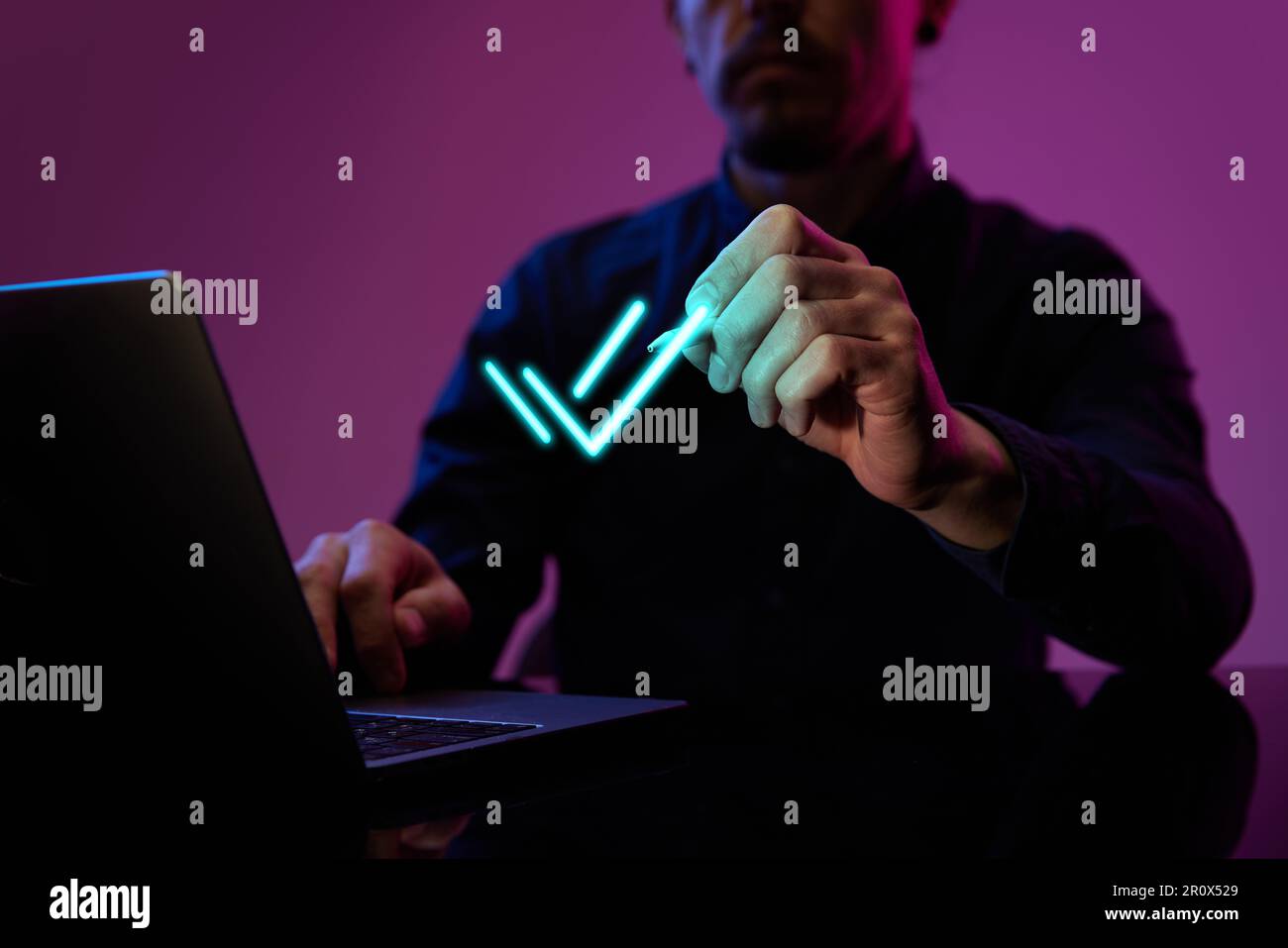 Businessman touching virtual, neon colored, digital icon. Finishing tasks. Development of convenient online service for customer usage Stock Photo