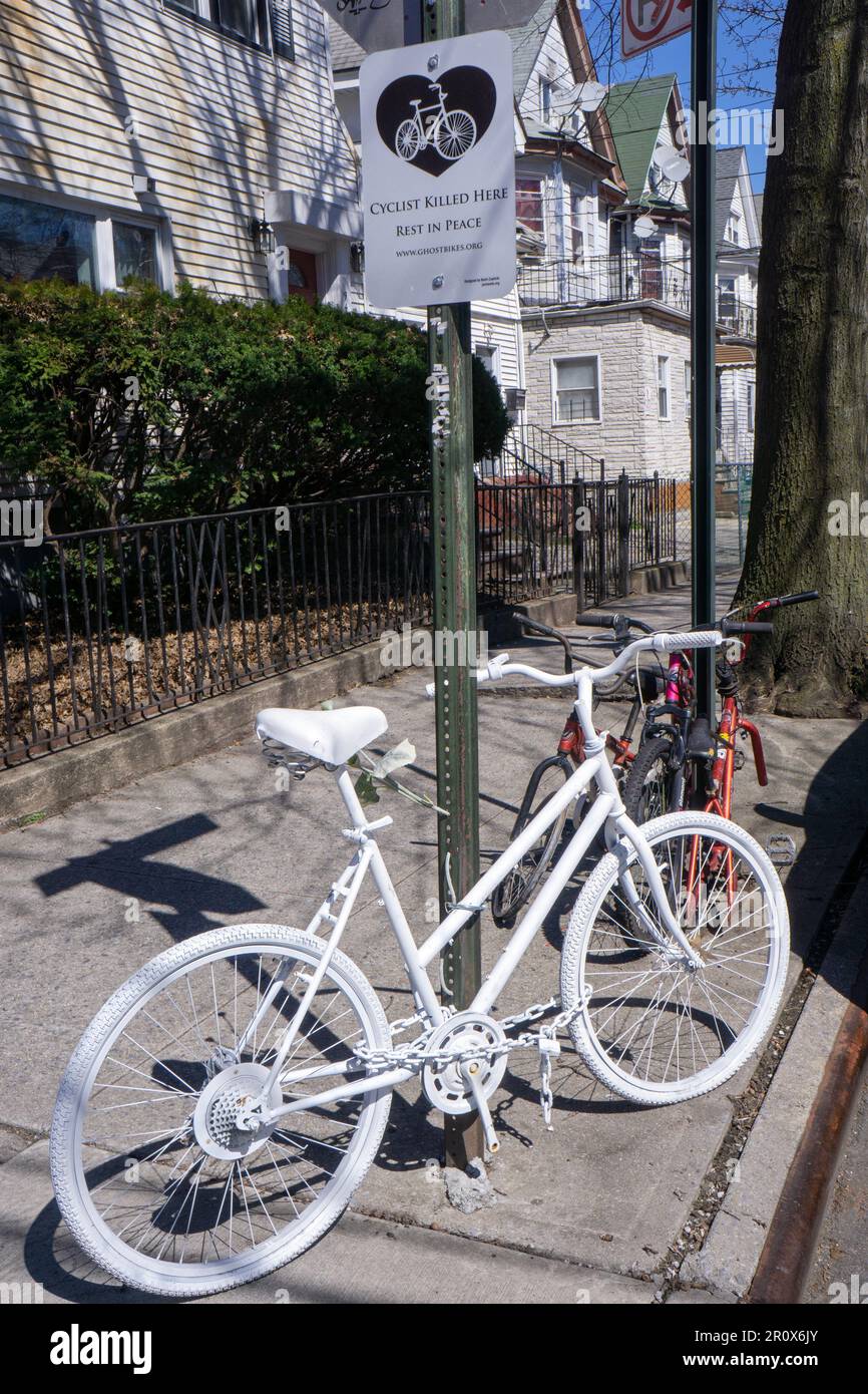 A completely white bicycle, a Ghost Bike  installed to commemorate a fatal bike crash. This on is 94th St & 40th Drive in Elmhurst, Queens, New York. Stock Photo