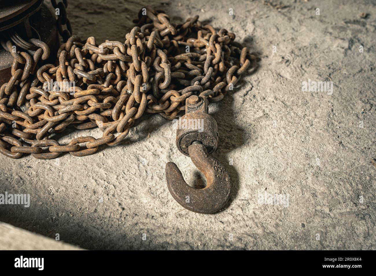 an old iron chain hoist with chain. a large hook for lifting loads