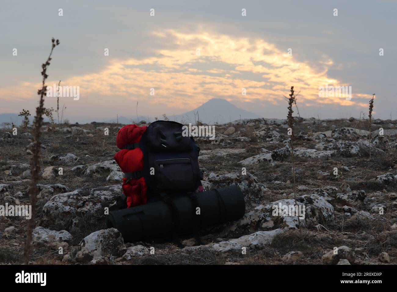 hiking at sunset, high mountain and backpack standing on the ground Stock Photo