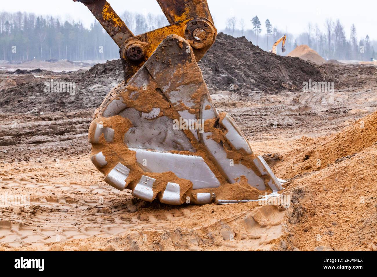 Excavator bucket in yellow sand Stock Photo