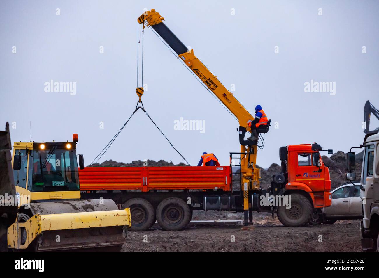 Ust-Luga, Leningrad oblast, Russia - November 16, 2021: Workers unloads concrete plates from truck Stock Photo