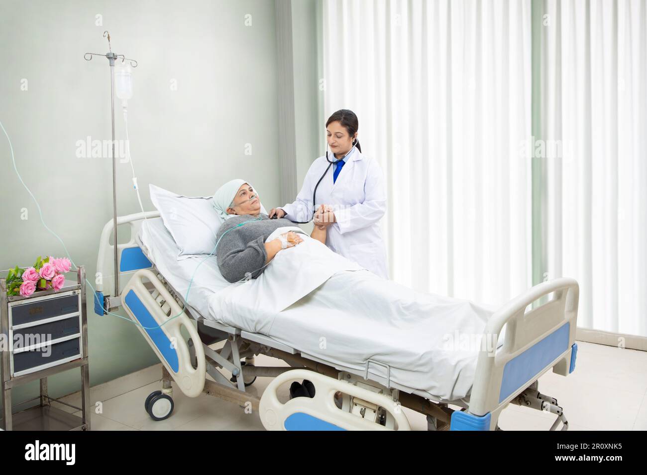 Indian doctor check heat beat of senior cancer patient undergoing course of chemotherapy in hospital. health care concept. Stock Photo