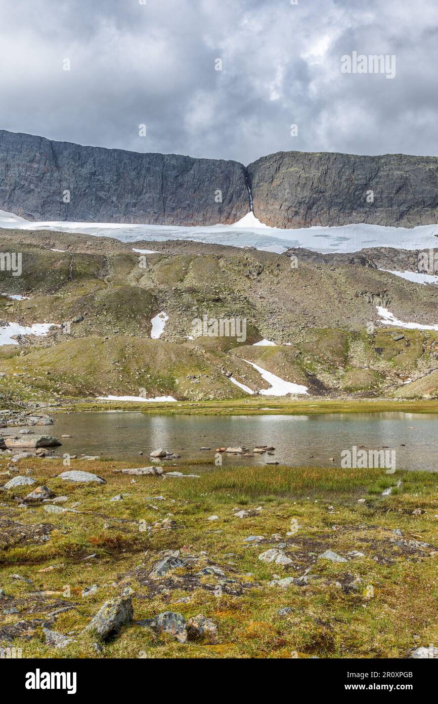 Glacier lake in the wilderness at a mountain valley with a small glacier Stock Photo