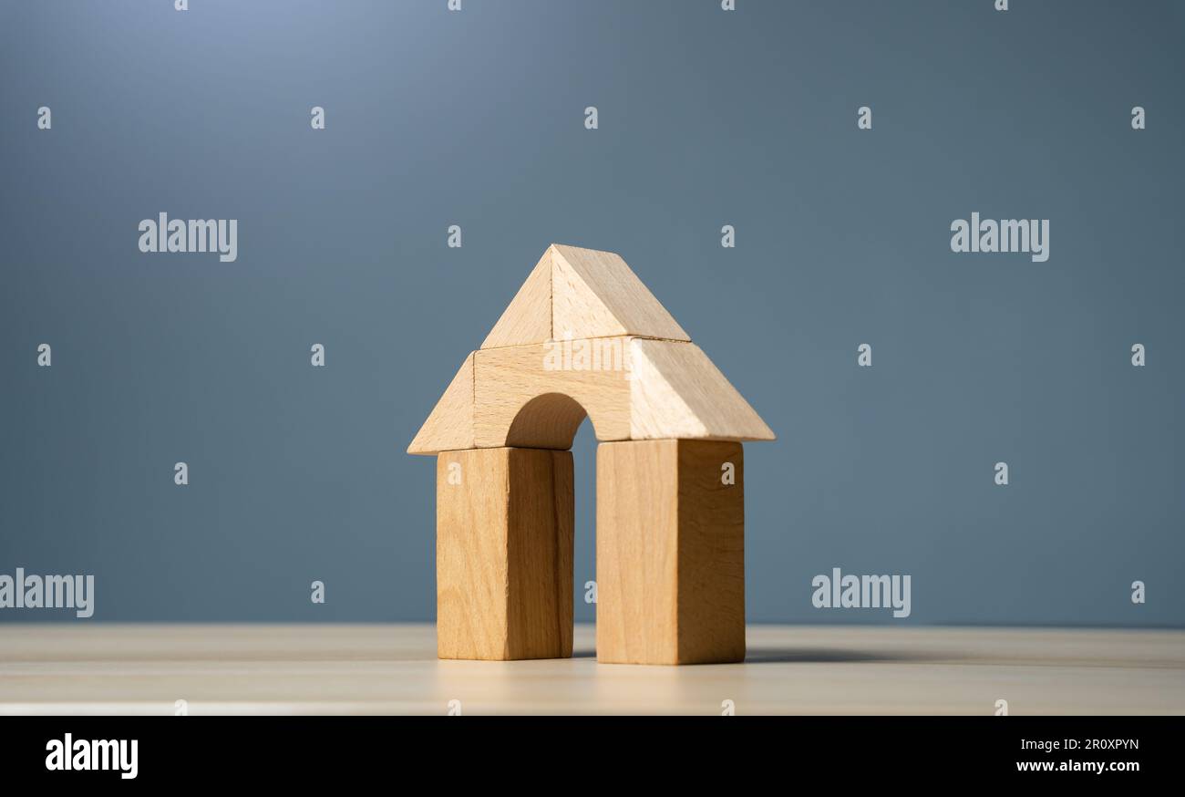 House made of wooden figures on a gray background. Buying and selling housing. Design and architectural services. Real estate market review. Construct Stock Photo