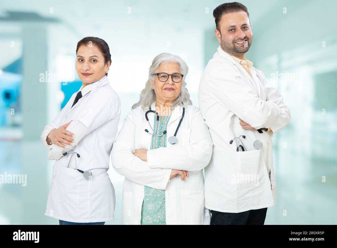 Team of indian doctors standing standing cross arms at hospital, healthcare and medical concept. Stock Photo