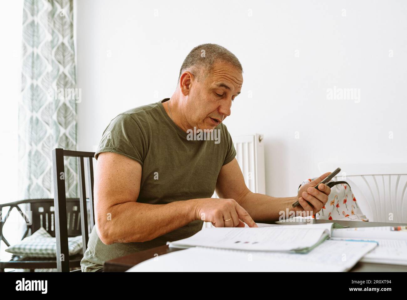 middle-aged man writes notes in notebook Stock Photo