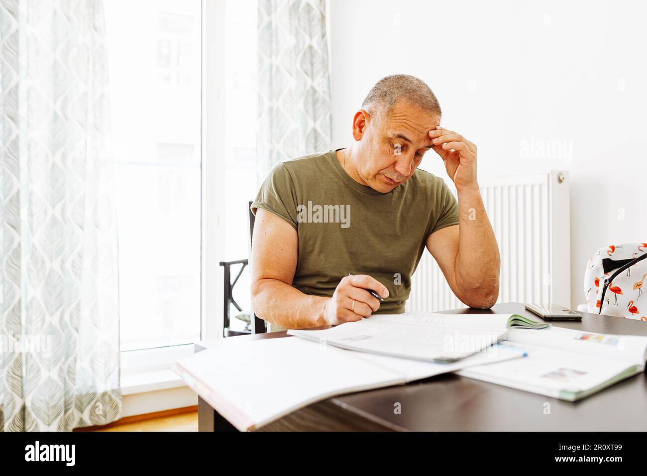 middle-aged man writes notes in notebook Stock Photo